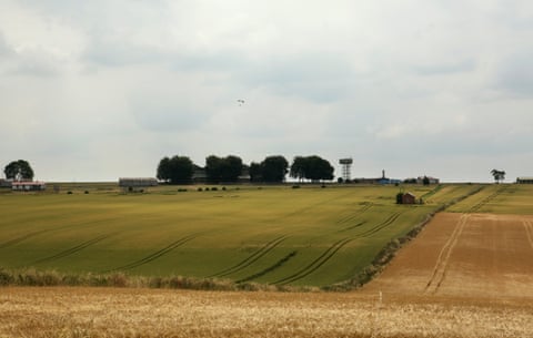Fields surrounding Netheravon airfield in Wiltshire, with a parachutist descending