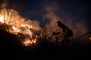 A firefighter works to extinguish a fire between the towns of Pinos Puente and Atarfe.