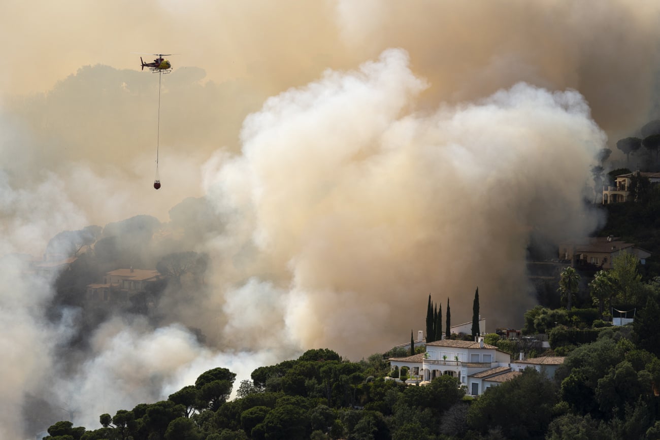 A helicopter pours water into the forest fire originated in Santa Cristina d’Aro, Girona, Spain, 01 July 2022