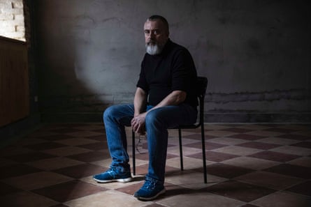 Maksym Kurochkin, a writer turned soldier, sitting on a chair in the new playwrights’ theatre in Kyiv, Ukraine