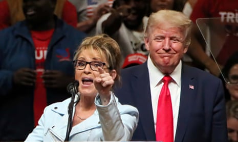 Sarah Palin gesturing while speaking as Donald Trump stands behind her, smiling