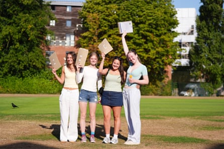 Four teenage girls hold up their results letters outside