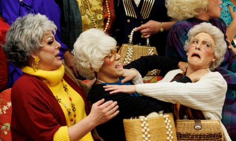 Eleven people cosplaying as the Golden Girls laugh and mug for the camera