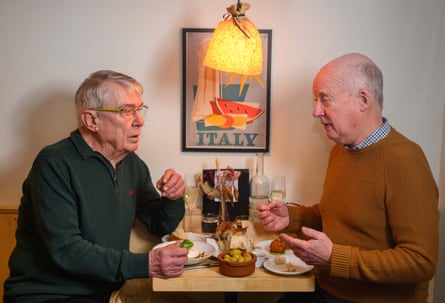 Two men facing each other across a restaurant table