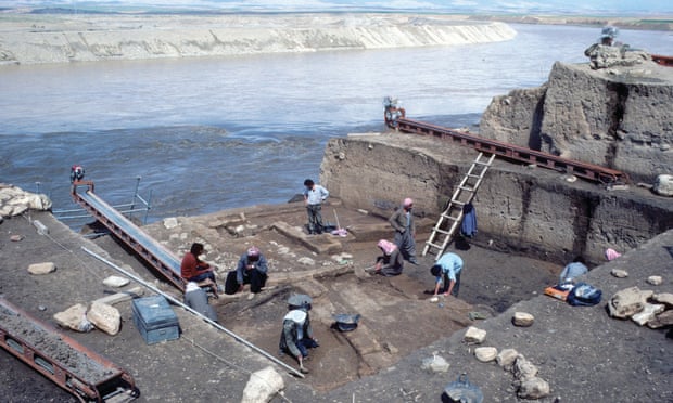 Spring 1985, British School excavations on the Tigris in advance of the Eski Mosul Dam. Excavators work in a large square trench next to a wide fast-flowing river.