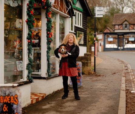 Self-described white witch Katrina Beaumont holding a dog outside her shop, Cobwebs & Crystals, in Burley village
