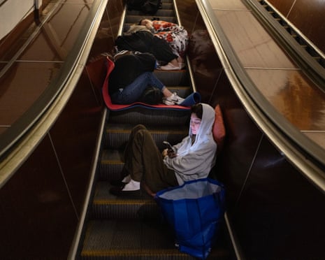 Residents rest on the escalator in the underground metro during an attack as Russian missiles and drones hit Kyiv.