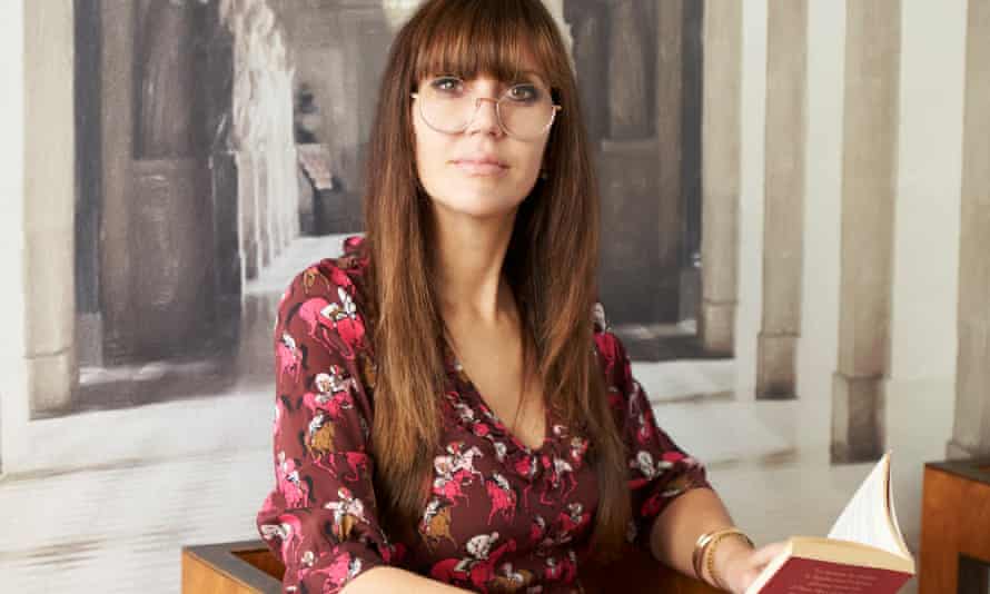 Cristina Sivieri Tagliabue, sitting, with a book open in her hands