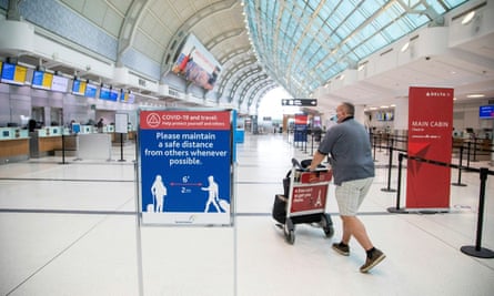 A man pushes a baggage cart wearing a mandatory face mask at Toronto Pearson international airport.