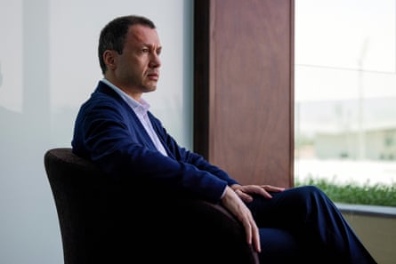 A man in a suit sitting on a chair by a window