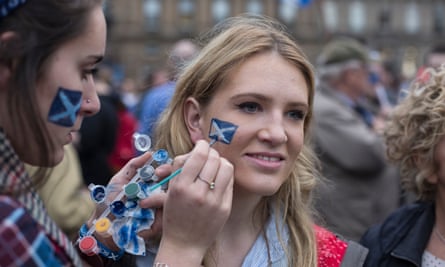 Young woman having face painted with a saltire