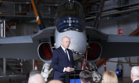 Peter Dutton giving a speech in front of a RAAF hornet fighter jet in a hangar