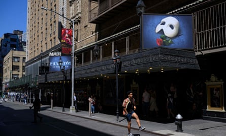 A person skates past the “Phantom of the Opera” marquee on April 13, 2023, at the Majestic Theater in New York City