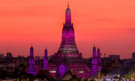 El sol se pone detrás de Wat Arun o el templo del amanecer en la víspera de Año Nuevo en BangkokLas luces iluminan Wat Arun o el templo del amanecer en la víspera de Año Nuevo en Bangkok, Tailandia, el 31 de diciembre de 2022.