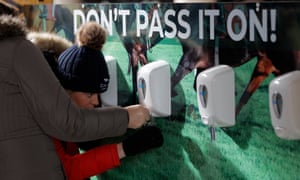 Racegoers filling up their own hand sanitiser bottles at the Cheltenham Festival.