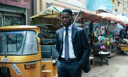 Toheeb Jimoh as Tunde Ojo, walking in a street market in The Power