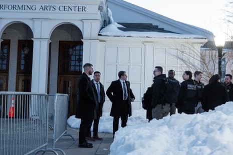 law enforcement officers stand outside a building