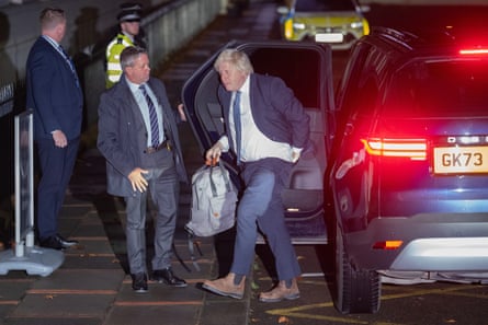 Boris Johnson looking a bit scruffy holding bag exits car at night