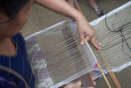 A woman working at a weaving loom