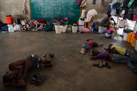 Young people in Haiti sleeping on the dirty floor of a school
