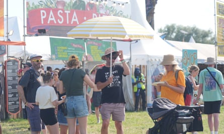 Festivalgoers at Glastonbury under a parasol