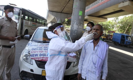 A health worker in a protective suit takes a mouth swab sample of a man to test for Covid in Delhi on Saturday.