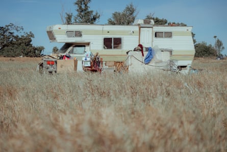 A camper seen through a field of dead grass