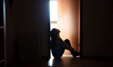 Girl in darkened area with back against wall