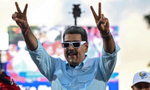 Nicolás Maduro holds up his hands in peace signs at an event in Caracas