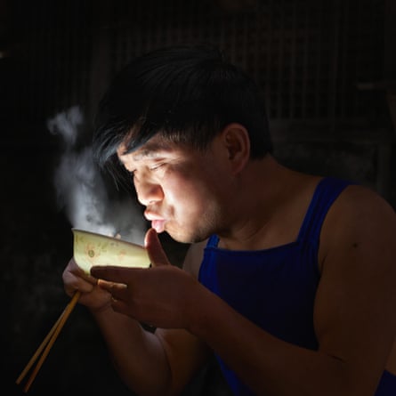 One of the teashop workers enjoys a lunchtime bowl of soup, China