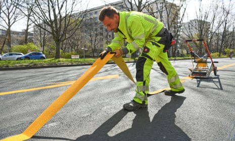 A worker lays a temporary cycle lane on a main road in Berlin