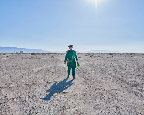 man in green uniform standing in the desert