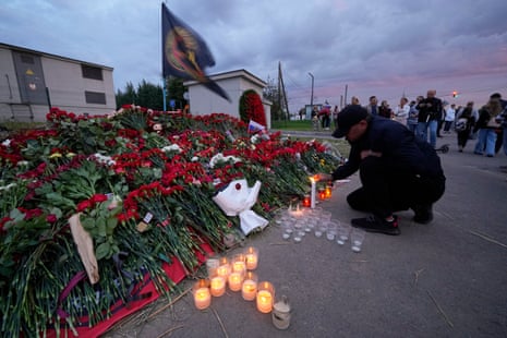A man lights candles at a informal memorial next to the former ‘PMC Wagner Centre’ in St. Petersburg, Russia, Thursday, Aug. 24, 2023. Russia’s civil aviation agency says mercenary leader Yevgeny Prigozhin was aboard a plane that crashed north of Moscow.