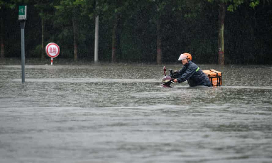 A courier wades through a waterlogged road in Zhengzhou, capital of central China’s Henan Province, July 20, 2021. More than 144,660 residents have been affected by torrential rains in central China’s Henan Province since July 16, and 10,152 have been relocated to safe places, the provincial flood control and drought relief headquarters said Tuesday. A total of 16 large and medium-sized reservoirs have seen water levels rise above the alert level after torrential rains battered most parts of the province on Monday and Tuesday. China Henan Zhengzhou Heavy Rainfall - 20 Jul 2021