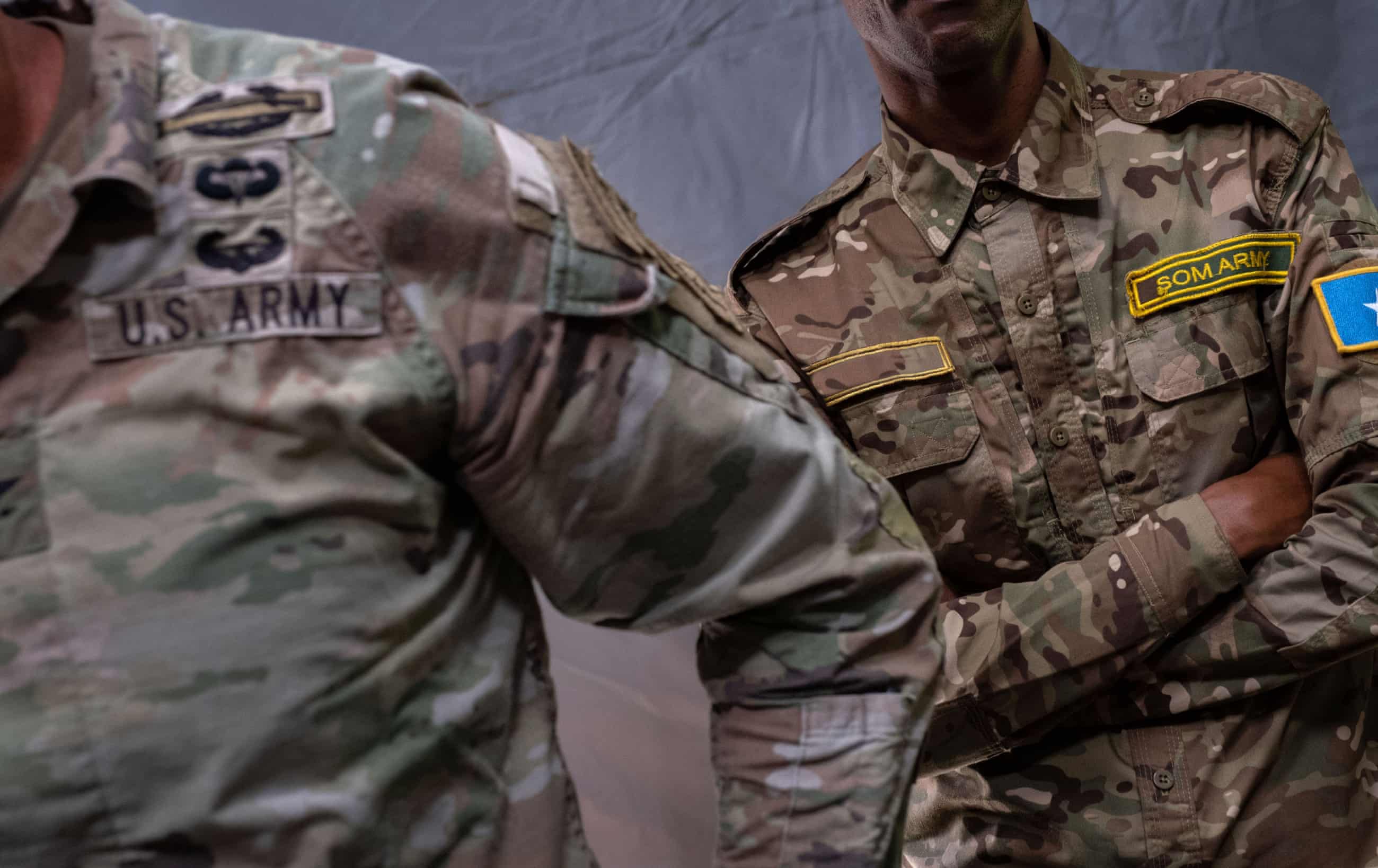 A US colonel and a somali soldier in camouflage uniforms with patches
