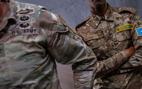 A US colonel and a somali soldier in camouflage uniforms with patches