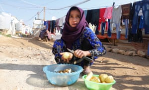A Syrian refugee peels potatoes at a refugee camp in Zahle in the Bekaa valley, Lebanon