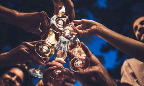 A group of people, pictured from below, clink wine glasses.