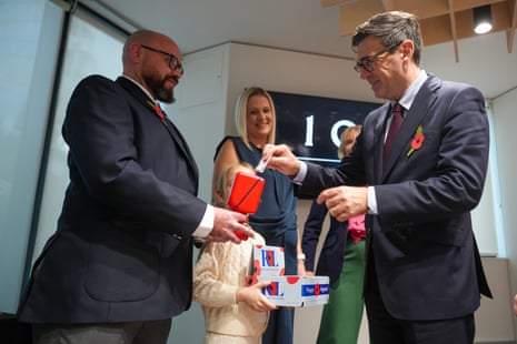 British Army veteran Steve Knighton holds a collection tin as British prime minister Andy Burnham makes a donation to the Poppy Appeal on 22 October.