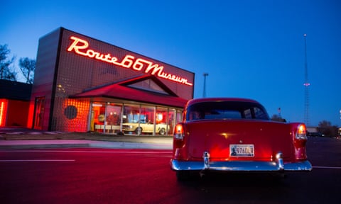 An old Chevrolet red car sitting outside Route 66 Museum at dusk