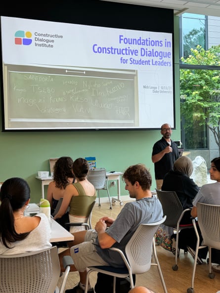 a man presents in front of people sitting