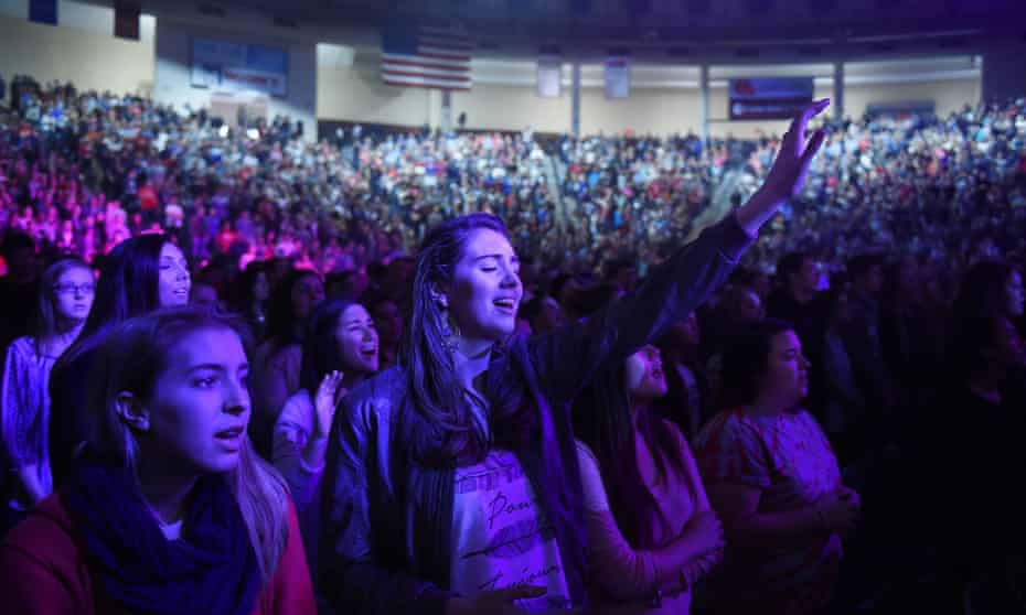 People listen to a Christian song during a convocation on the campus of Liberty University, founded by Jerry Falwell.