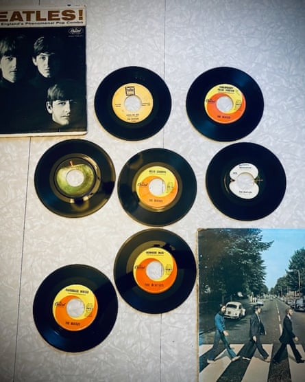 Seven music albums hang on a wall with a Meet the Beatles! record jacket.