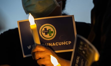 A nurse from the Kaiser Permanente Woodland Hills medical center holds an electric candle during a candlelight vigil in memory of those lost during the coronavirus pandemic in Woodlands Hills, California, in May.