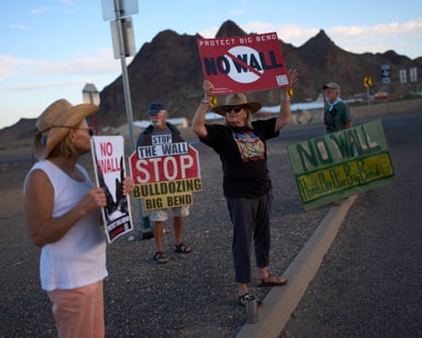 Protesters hold up signs during a protest against barriers along the border in the Big Bend region