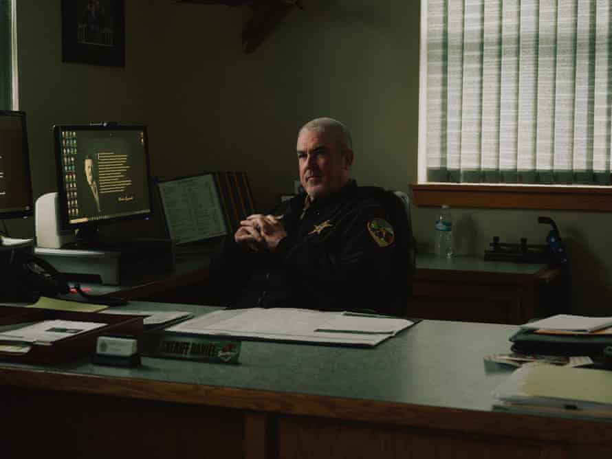 A sheriff sits at his desk with his computer screen on