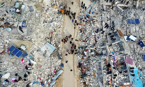 This aerial view shows residents searching for victims and survivors amid the rubble of collapsed buildings following an earthquake in the village of Besnia near the town of Harim, in Syria’s rebel-held north-western Idlib province on the border with Turkey.