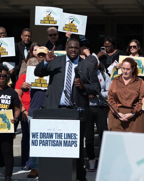 A group of people protesting outside with no partisan map signs