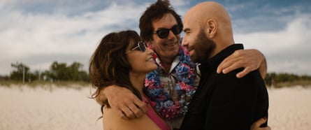 Gina Gershon hugs Lukas Haas and John Travolta on a beach