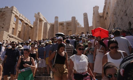 Visitors walk in front of the Acropolis during a heatwave in Athens, Greece, on 14 July.